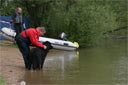Picture of owner and black newfoundland dog waiting on shore at start of exercise one
