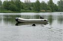 picture of black newfoundland dog approaching moored boat