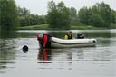 picture of black newfoundland dog towing boat to shore